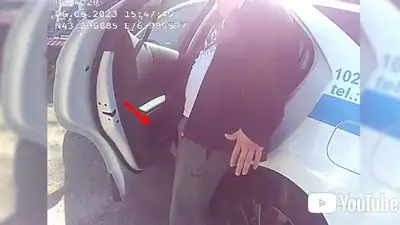  30 тыс. тенге в полицейскую машину в Алматы, фото - Новости Zakon.kz от 16.05.2023 19:48