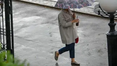 человек под зонтом  , фото - Новости Zakon.kz от 19.04.2022 14:55