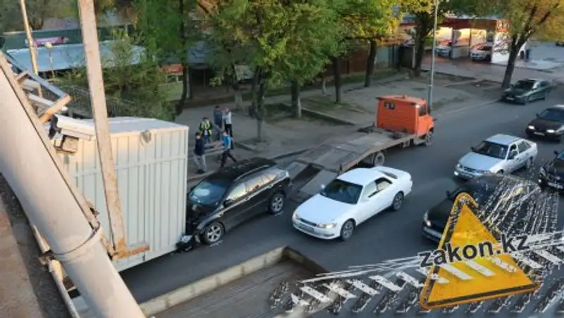 Контейнер ударился о пешеходный мост и упал на машину в Алматы