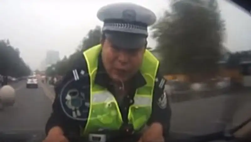 Китайского полицейского 2 часа катали на капоте автомобиля