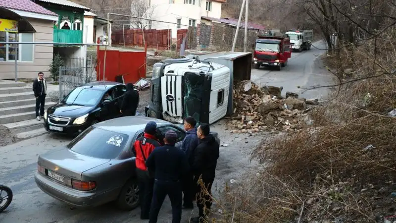 Грузовик со строительным мусором снес забор и перевернулся на дороге в Алматы