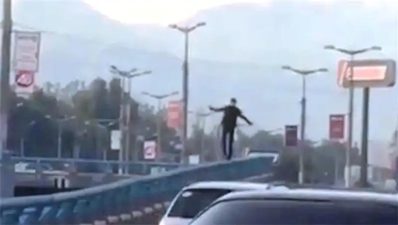 Опасная забава: алматинец изображает из себя канатоходца на дороге
