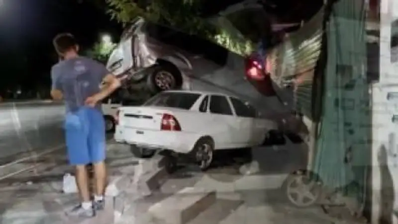 Автомобиль в результате ДТП повис на дереве недалеко от прокуратуры в Шымкенте