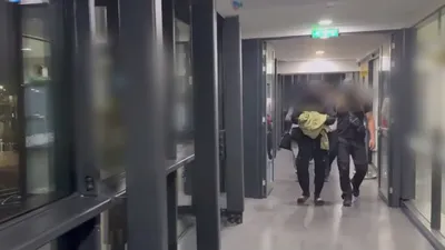 силовик ведет в аэропорту задержанного мужчину, фото - Новости Zakon.kz от 19.05.2025 09:41