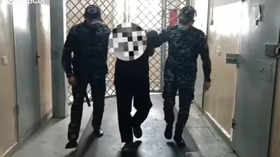 задержанного в Сатпаеве мужчину ведут на допрос, фото - Новости Zakon.kz от 23.05.2025 13:10