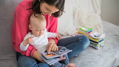 мама показывает ребенку книги, фото - Новости Zakon.kz от 14.08.2025 16:42