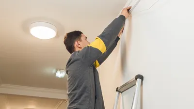 Мужчина проводит кабель  интернета , фото - Новости Zakon.kz от 17.02.2026 10:00