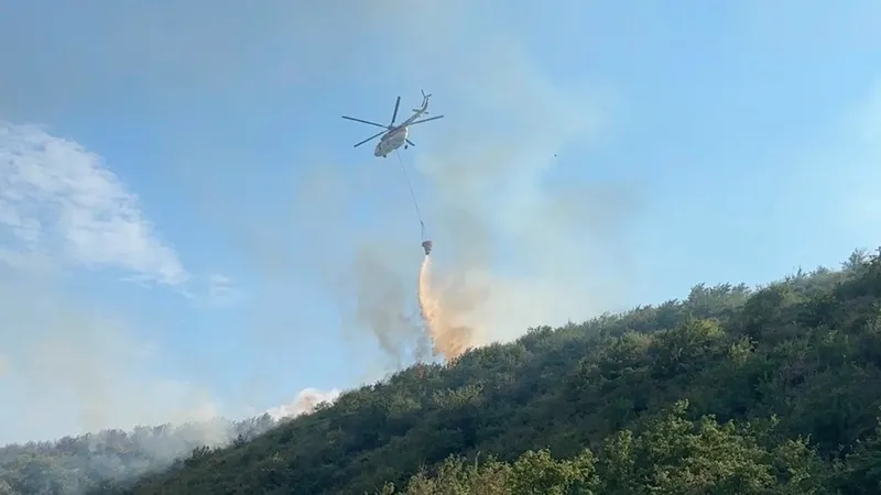 вертолет тушит возгорание в горной местности